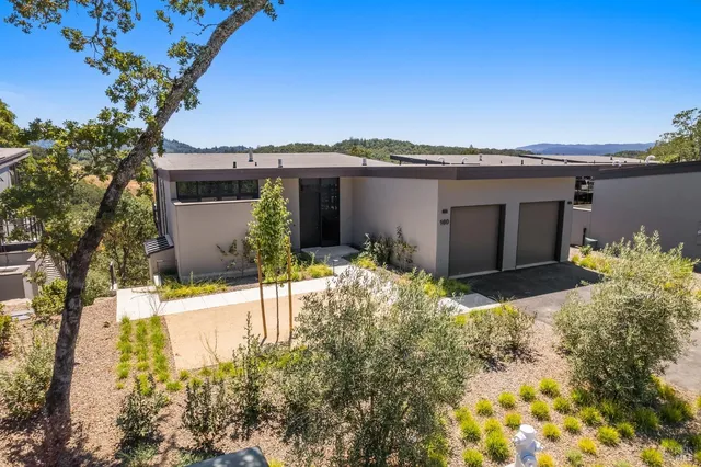 a front view of a house with a yard and mountain view