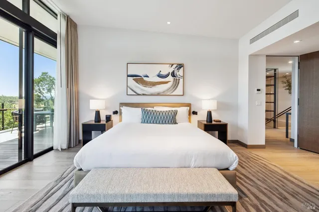 a bedroom with two beds and large windows