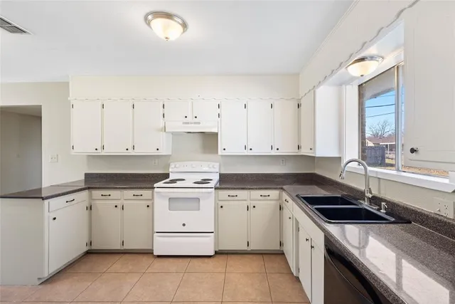 a kitchen with a stove sink and cabinets