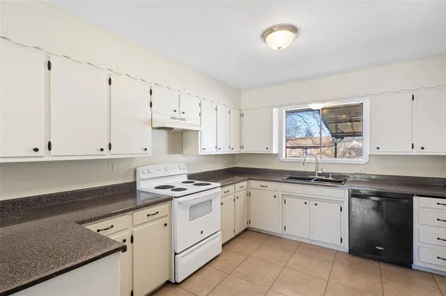 a kitchen with cabinets appliances a sink and a window
