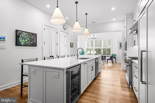 a kitchen with stainless steel appliances kitchen island a large island in the center cabinets and wooden floor