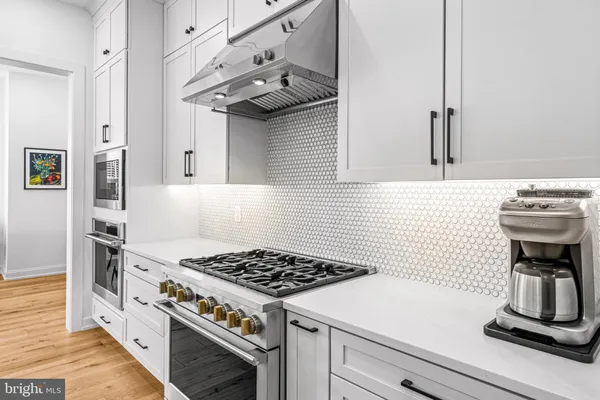 a large kitchen with stainless steel appliances kitchen island granite countertop a stove a sink and a refrigerator