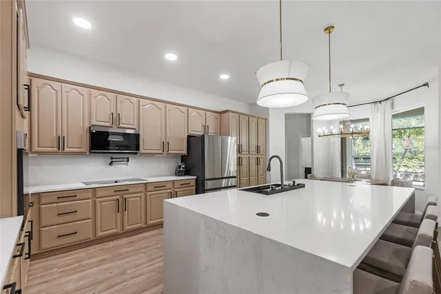 a kitchen with kitchen island granite countertop a sink a counter space appliances and cabinets