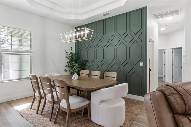 a dining room with furniture a chandelier and window