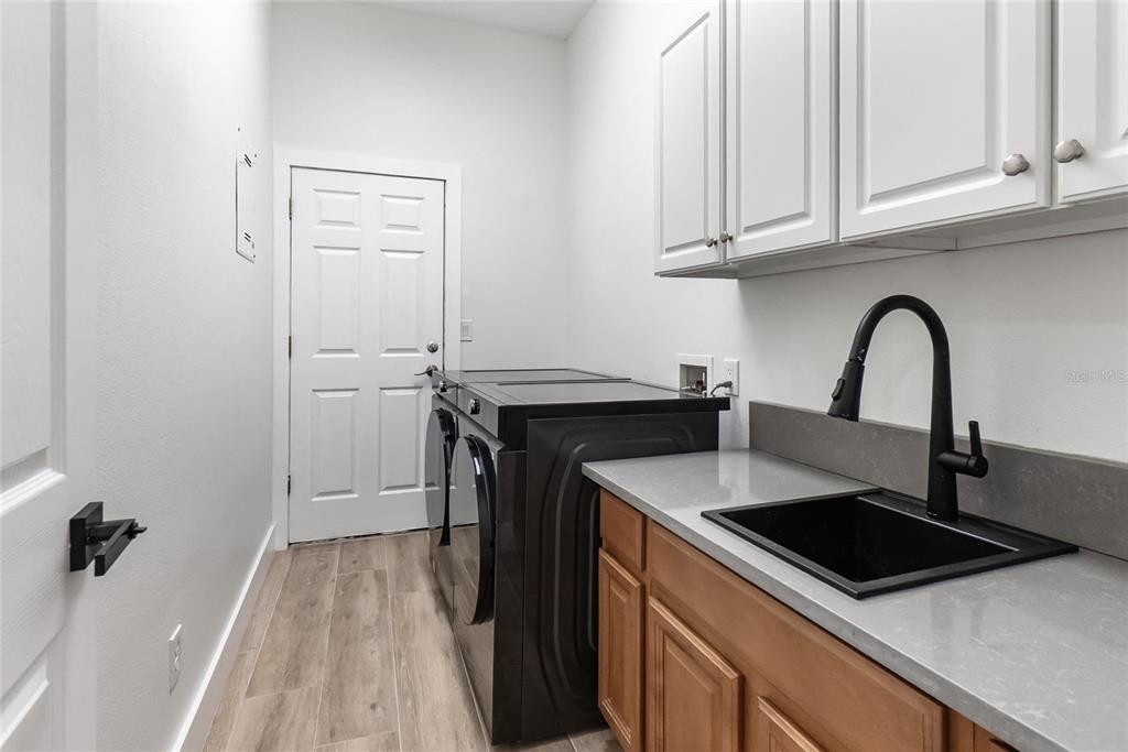 12516 24th Street East Parrish, FL 34219 - Photo 10 of 47 a kitchen with granite countertop a sink stove and refrigerator