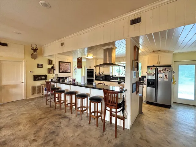 a kitchen with stainless steel appliances kitchen island granite countertop a refrigerator and microwave