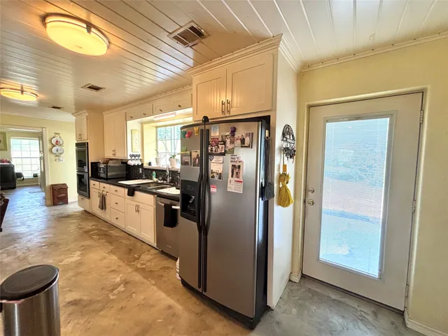 a kitchen with stainless steel appliances granite countertop a refrigerator a stove and a sink