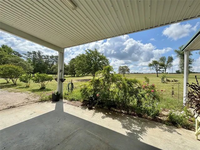 a view of a patio with table and chairs under an umbrella