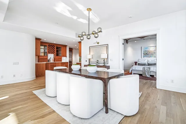 a living room with furniture a chandelier and wooden floor