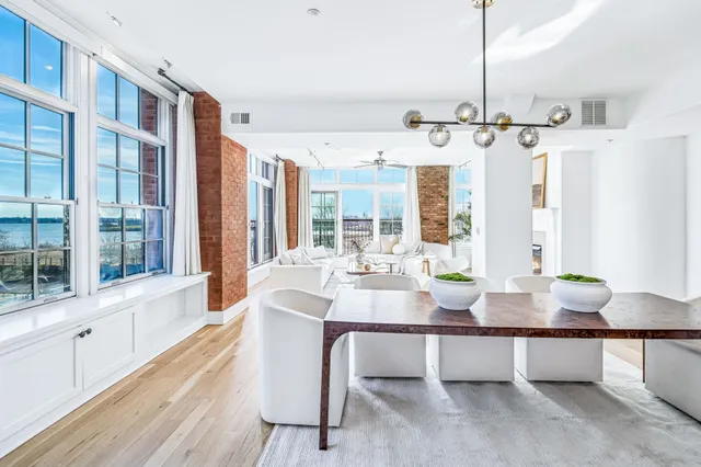 a view of a dining room and livingroom with furniture wooden floor a chandelier