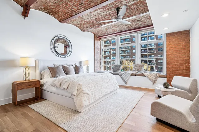 a bedroom with a bed couch and a large window