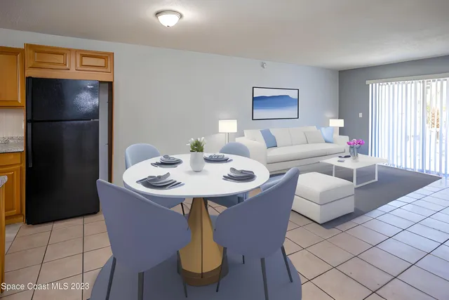 a living room with furniture and a refrigerator