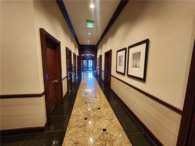 a hallway with wooden floor and stairs
