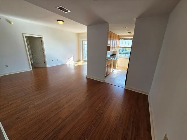 a view of a big room with wooden floor and windows