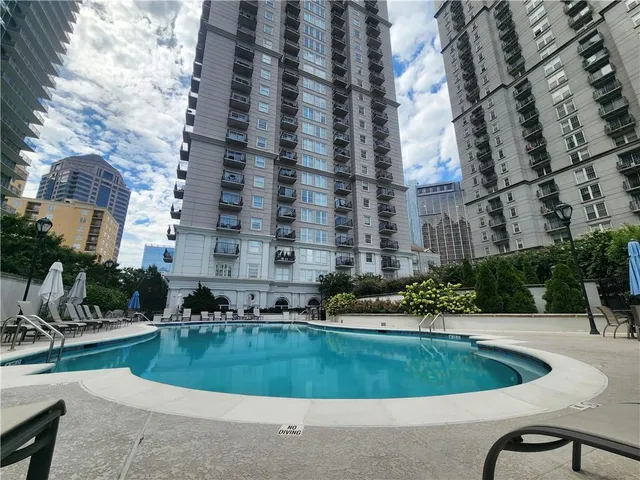 a view of a swimming pool with a yard and plants