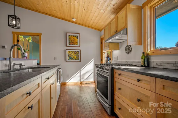a kitchen with granite countertop a sink and wooden floor