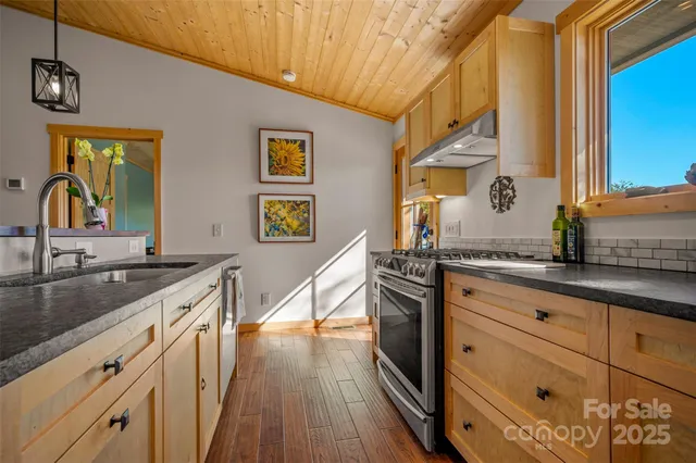 a kitchen with granite countertop a sink and wooden floor