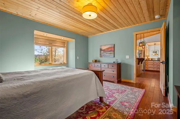 a bed sitting in a spacious bedroom next to a window