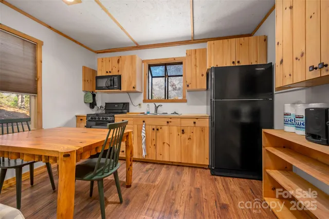 a bedroom with a bed and a dresser with wooden floor