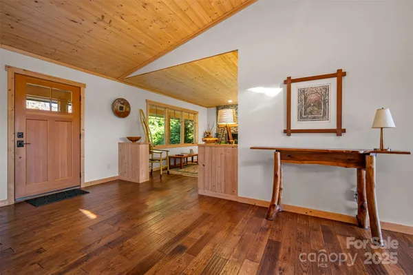 a view of an empty room with kitchen and a window