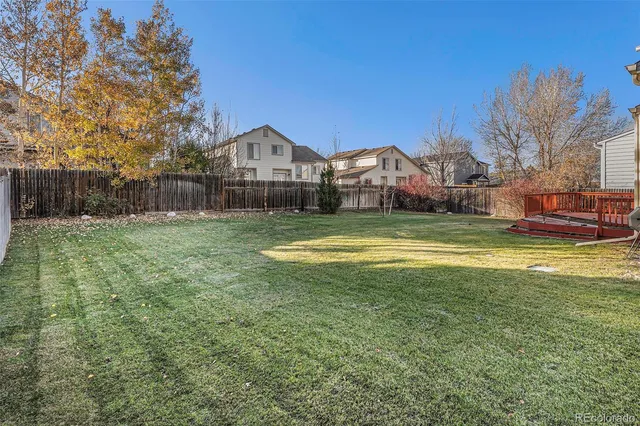 a view of a house with a big yard and large trees