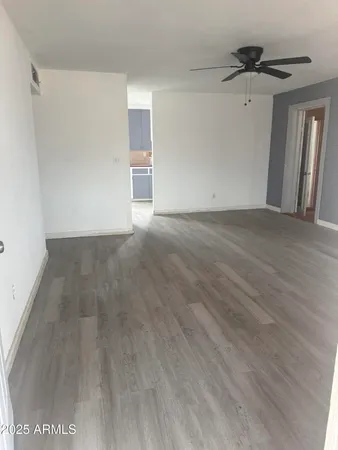 a view of a livingroom with wooden floor and a ceiling fan