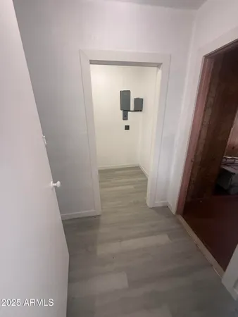 a view of a hallway with wooden floor and a living room