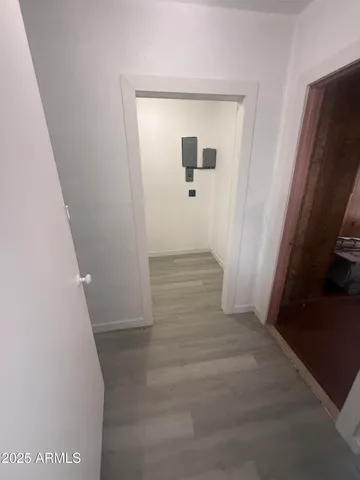 a view of a hallway with wooden floor and a living room