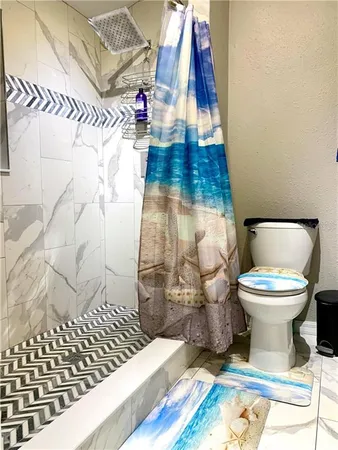 a bathroom with a toilet and a shower curtain