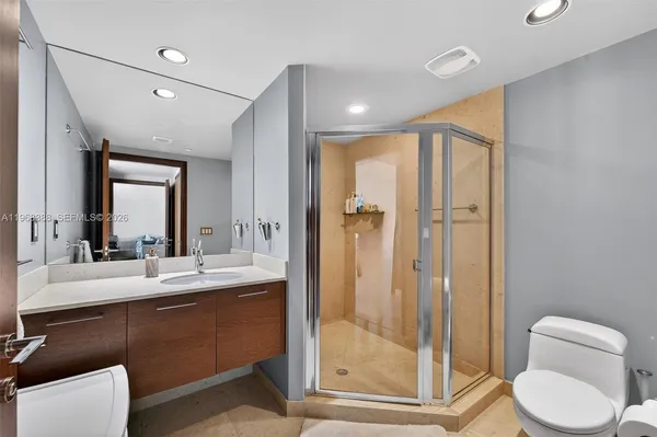a bathroom with a double vanity sink toilet mirror and shower