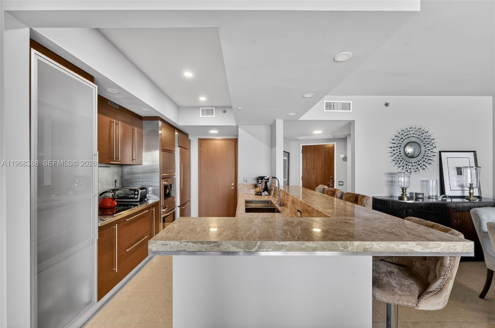 450 Alton Road, Unit 1202 Miami Beach, FL 33139 - Photo 6 of 15 a kitchen with granite countertop a sink stainless steel appliances and cabinets