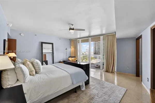 a spacious bedroom with a bed and glass windows