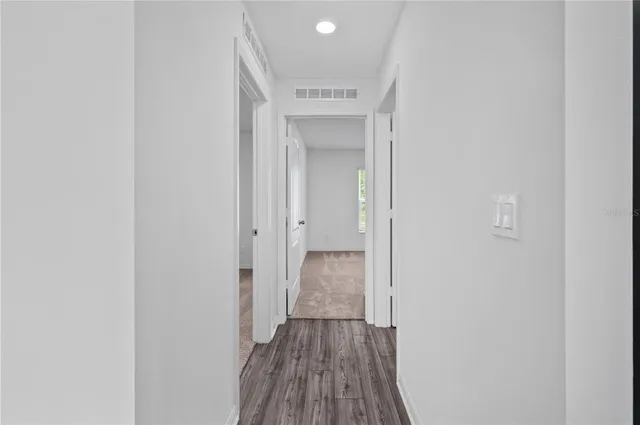 a view of a hallway with wooden floor