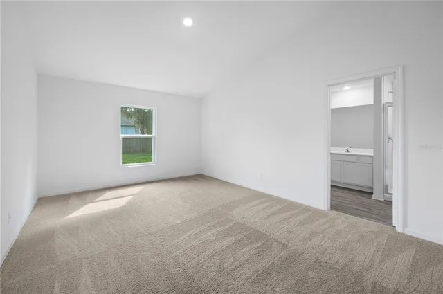 an empty room with a bathroom and a window