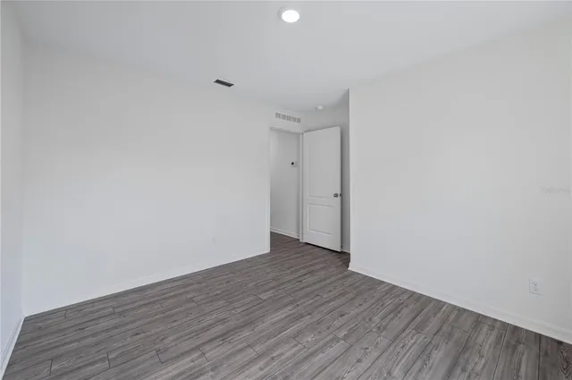 a view of an empty room with wooden floor
