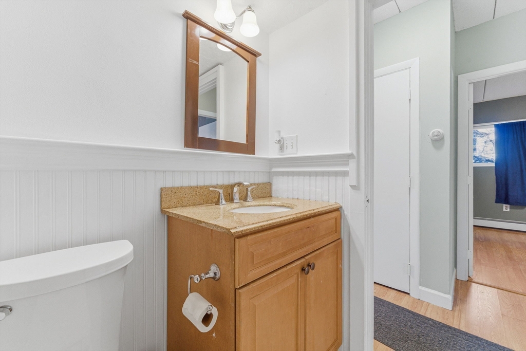 1011 Main Street, Unit 5 Woburn, MA 01801 - Photo 13 of 26 a bathroom with a granite countertop sink and a toilet