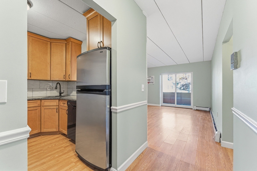 1011 Main Street, Unit 5 Woburn, MA 01801 - Photo 2 of 26 a kitchen with stainless steel appliances granite countertop a refrigerator a stove top oven a sink and dishwasher