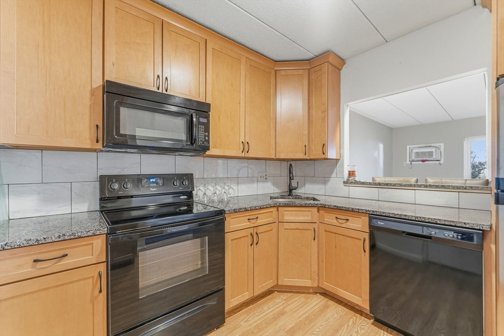 1011 Main Street, Unit 5 Woburn, MA 01801 - Photo 3 of 26 a kitchen with granite countertop cabinets stainless steel appliances and a counter space