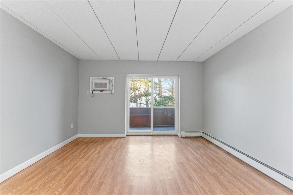 1011 Main Street, Unit 5 Woburn, MA 01801 - Photo 9 of 26 wooden floor in an empty room with a window