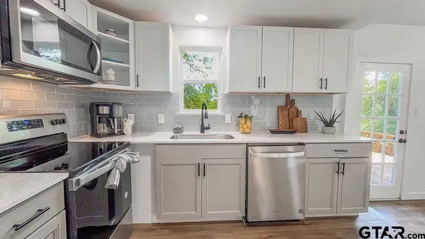 a kitchen with cabinets stainless steel appliances and a sink