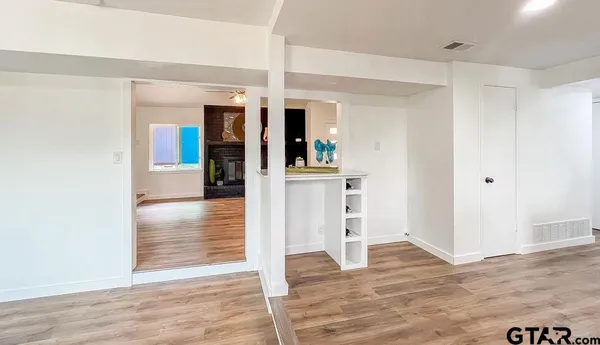 a view of a hallway with wooden floor and closet