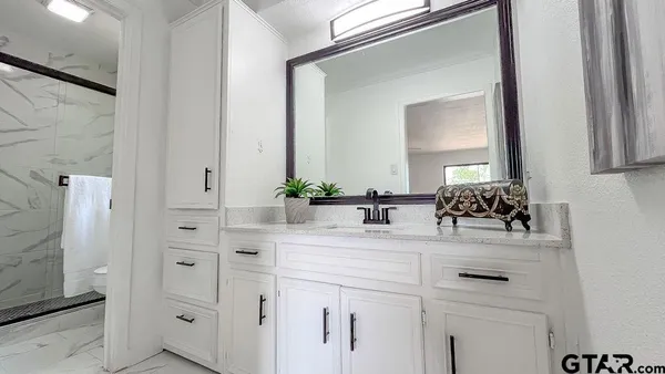 a bathroom with a sink vanity granite and a mirror