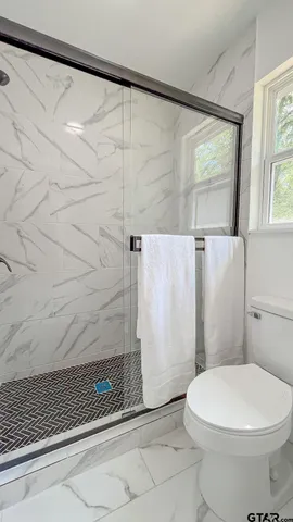 a bathroom with a toilet and a shower