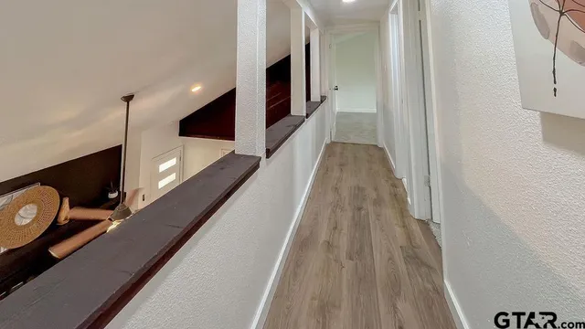 a view of a hallway with wooden floor and staircase