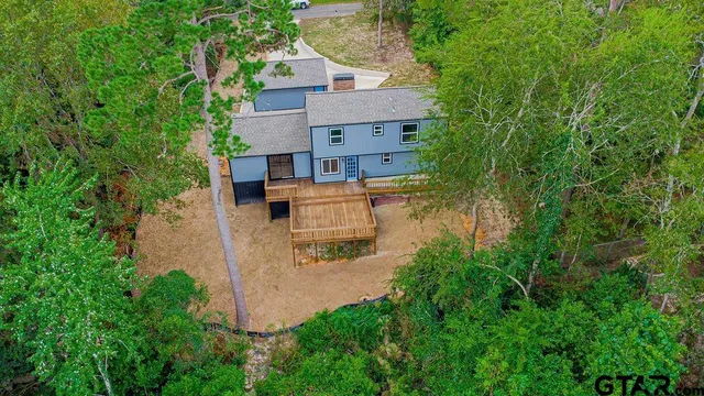 an aerial view of a house with a yard and large trees