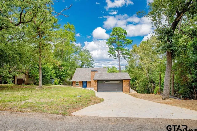 a front view of a house with a yard and fountain