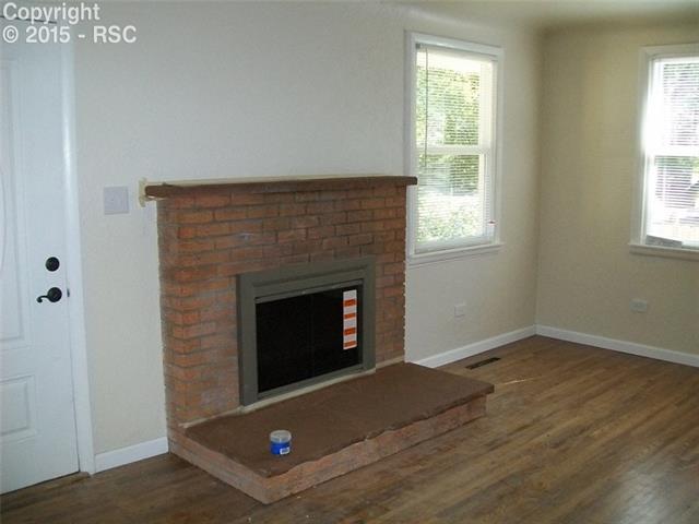 612 Sunset Road Colorado Springs, CO 80909 - Photo 4 of 27 Living Room W/ Wood Burning Fireplace & Refinished Hardwood Floors