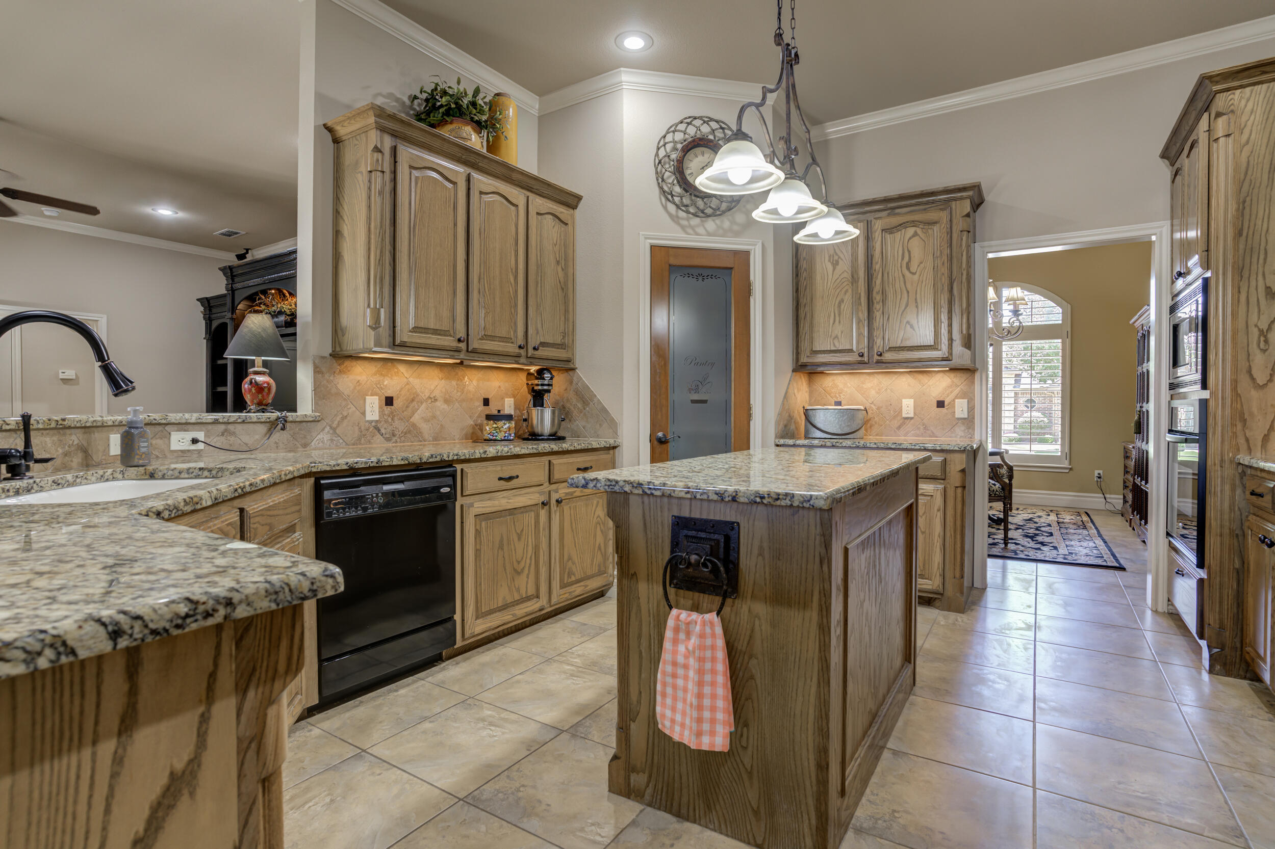 6008 89th Street Lubbock, TX 79424 - Photo 17 of 61 a kitchen with granite countertop a sink a stove top oven and cabinets