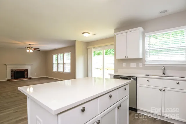 a kitchen with granite countertop a sink appliances cabinets and a counter top space