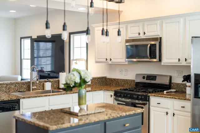 a kitchen with stainless steel appliances granite countertop a stove a sink and a granite counter tops